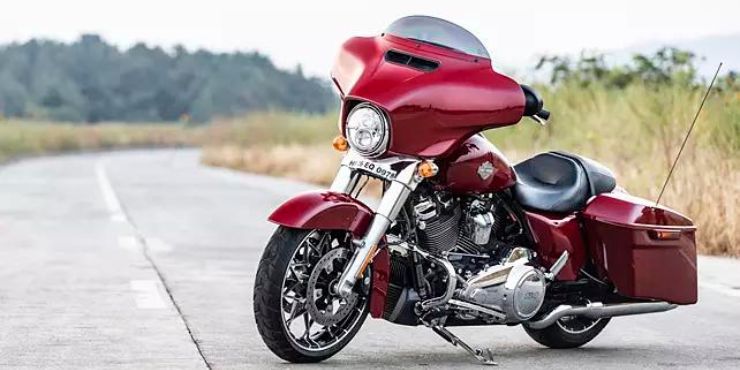 red harley davidson street glide parked in the road