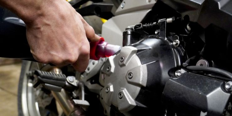 Person Putting Oil On Harley-Davidson Engine