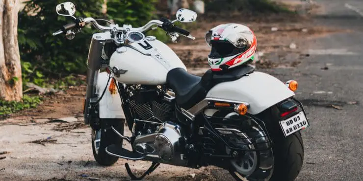 White Harley-Davidson Parked In The Road With Helmet On Seat 