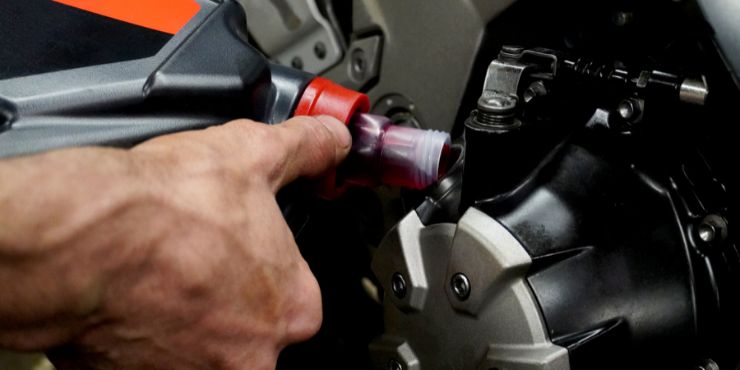 Person Filling Harley-Davidson Motorcycle With Fresh Oil