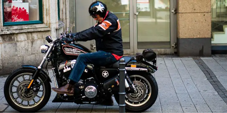 Old Man In Professional Riding Attire Sitting In A Harley Davidson Motorcycle