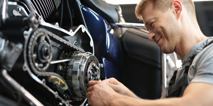 Person Inspecting The Derby Cover Gasket In Harley-Davidson Road King Bike