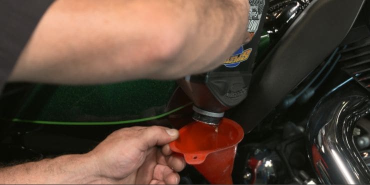 Person Changing Oil On Harley Softail