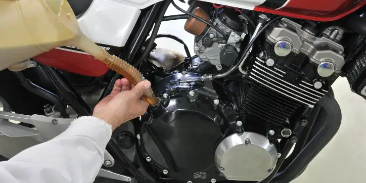 Person Adding Oil On Motorcycle