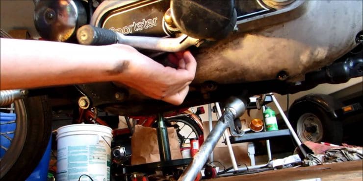 How To Check Sportster Transmission Oil - Person Checking Harley Davidson Sporter Transmission Oil