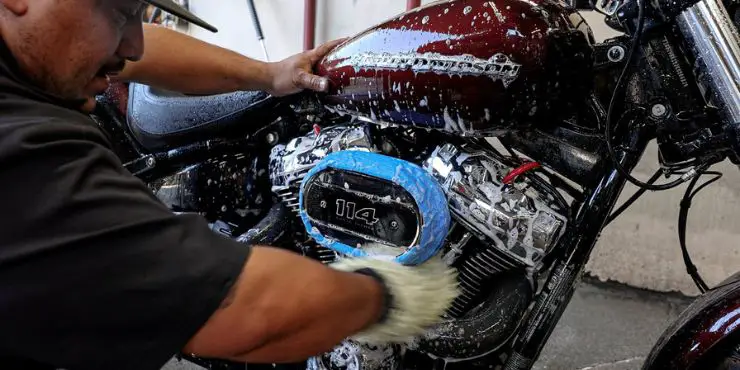 person cleaning harley-davidson bike