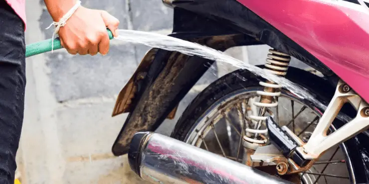 How To Clean Motorcycle Tires - Person Cleaning Motorcycle Using Water Hose