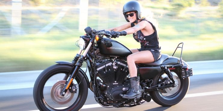 Professional Woman Rider Driving A Harley-Davidson Sportster Fast With Lowered Seat