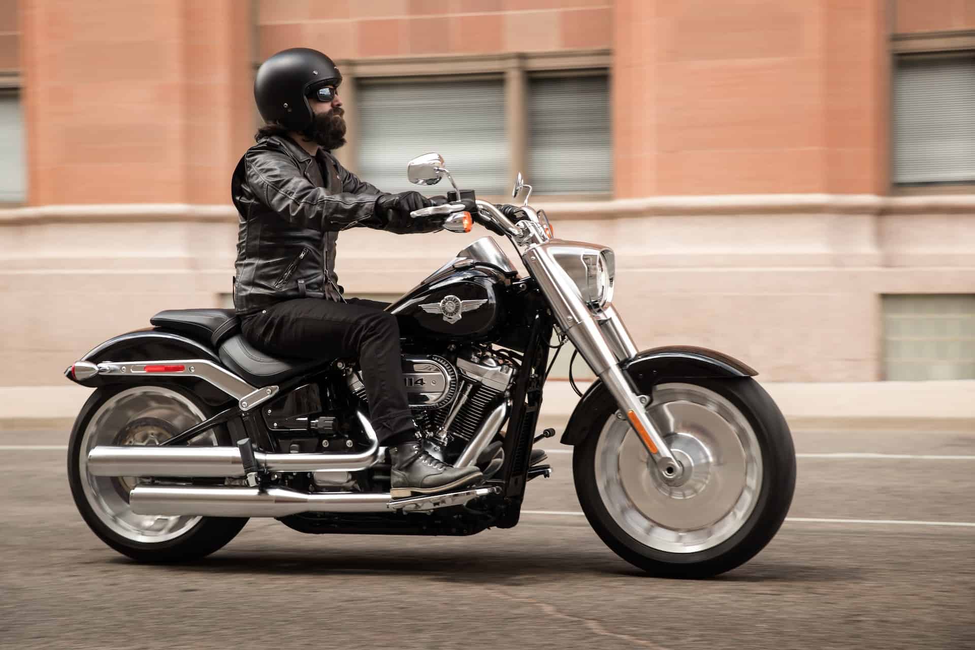 how to ride a harley davidson for the first time - man wearing helmet riding harley davidson