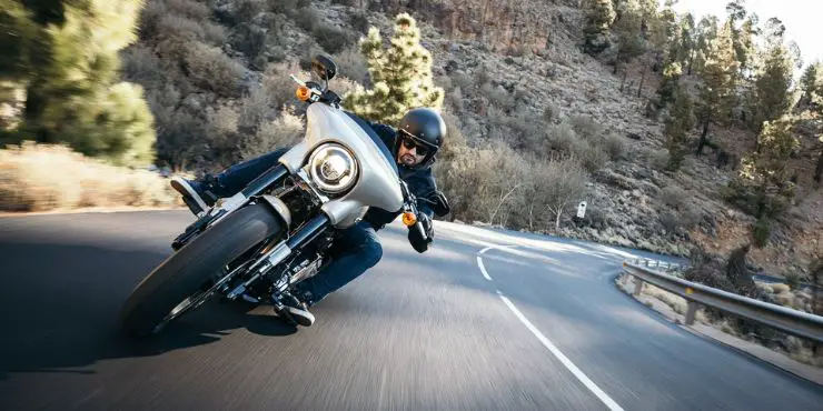 Professional Rider Driving His Harley-Davidson Street Glide Fast On Hills Highway