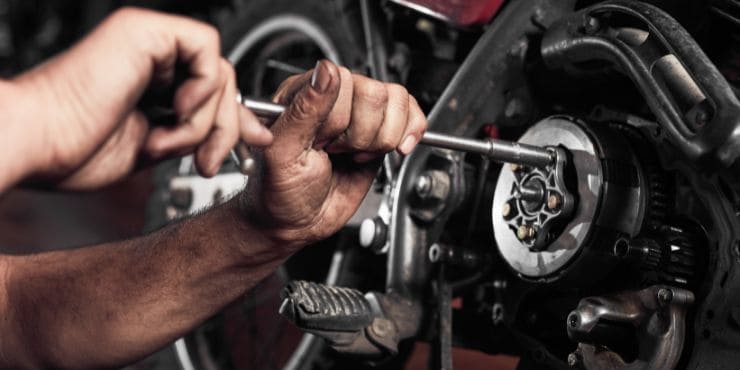 A Person Trying To Open Harley Stator Using A Tool