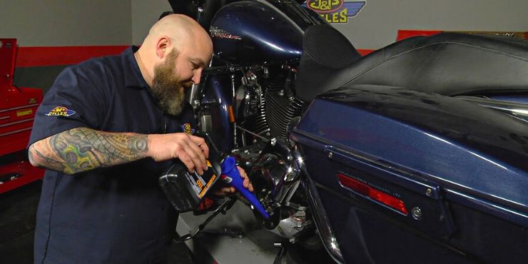 Person Putting Primary Oil On A Harley-Davidson Bike