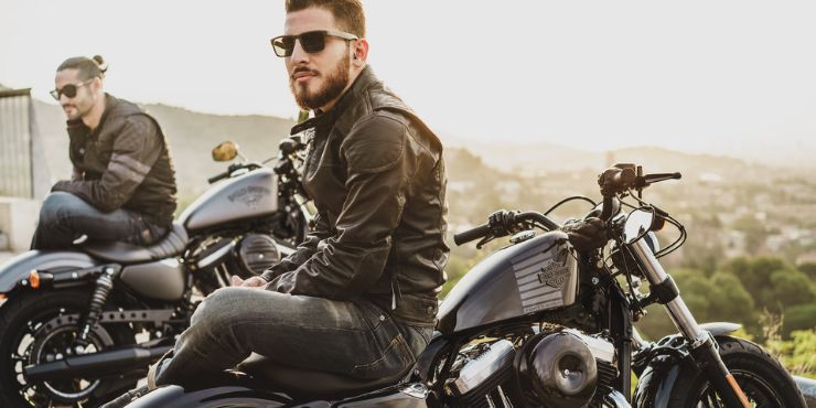 professional harley davidson rider wearing leather jacket while sitting in motorcycle