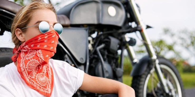 Why Do Bikers Wear Bandanas - Woman Rider Sitting Down Wearing Sunglasses And Bandana 